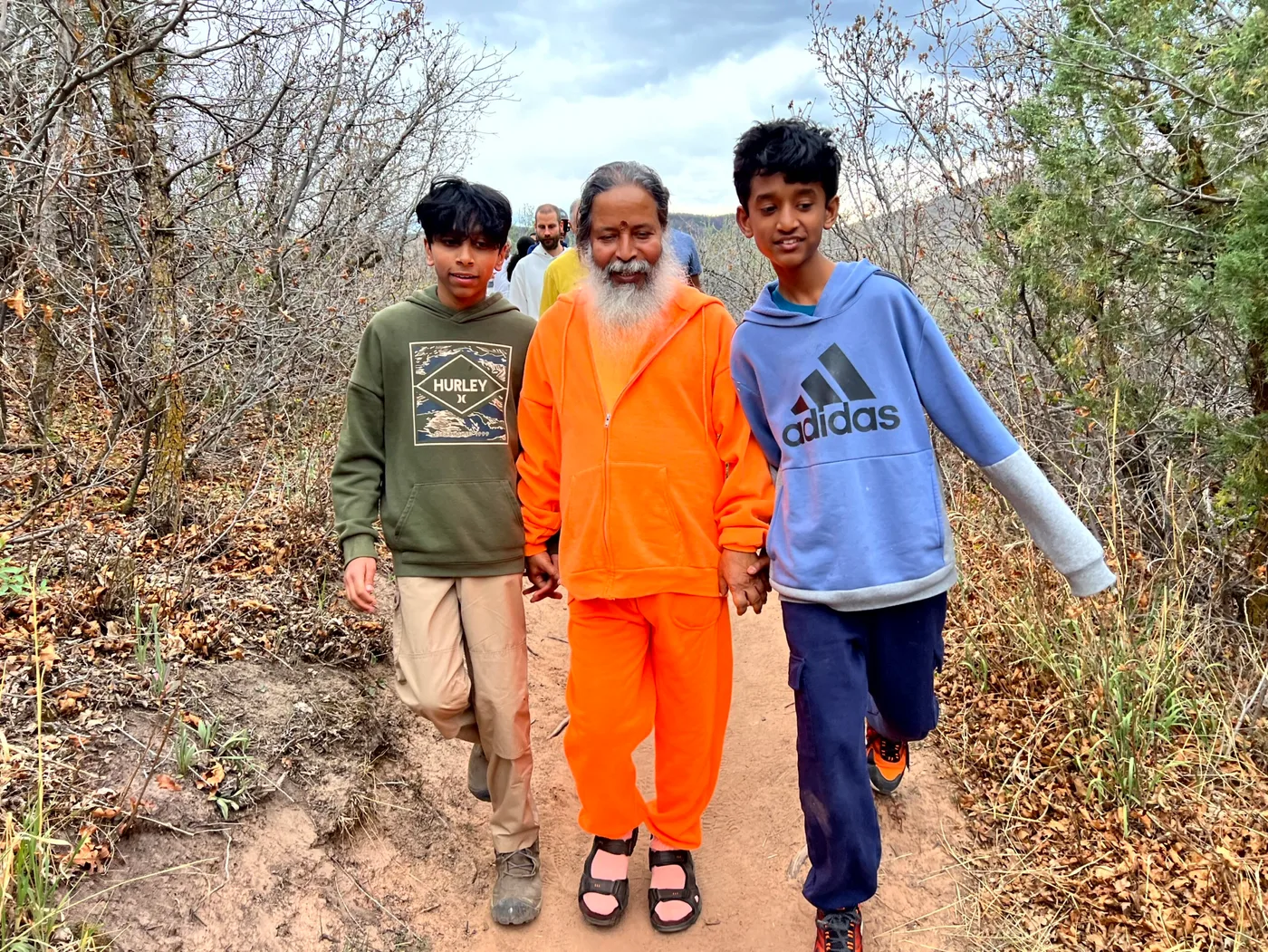 A teacher walking with children on a Colorado trail